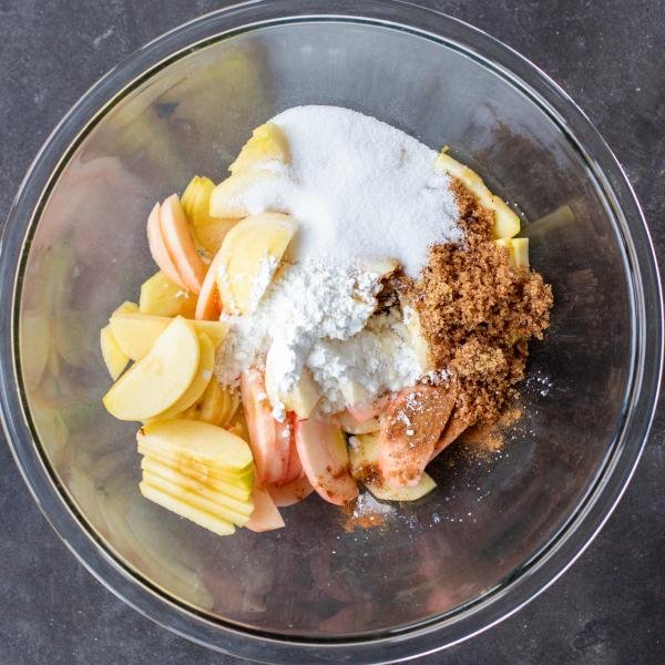 Apples, sugar, cinnamon are in a bowl.