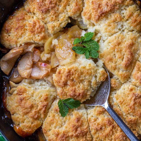 Apple Cobbler in a pan with a spoon.