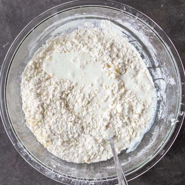 Buttermilk added to the biscuits dough in a bowl.