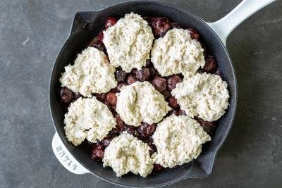 Cherries in a baking pan with cobbler topping before baking.