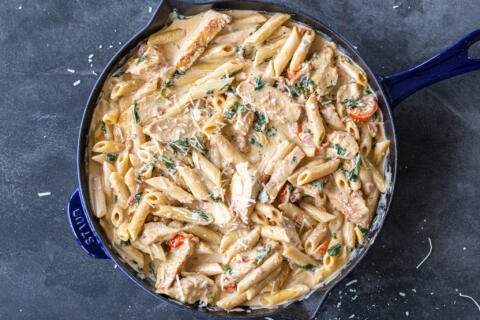 Creamy Tuscan Chicken Pasta with Parmesan in a pan.