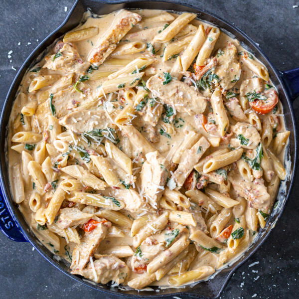 Creamy Tuscan Chicken Pasta with Parmesan in a pan.