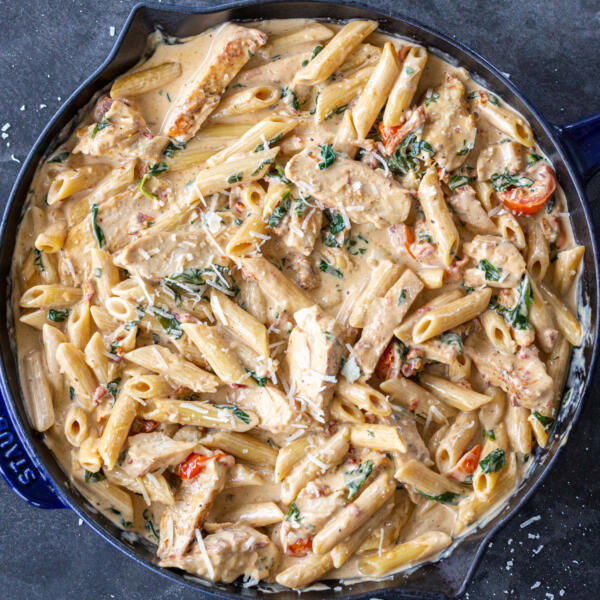 Creamy Tuscan Chicken Pasta with Parmesan on top.