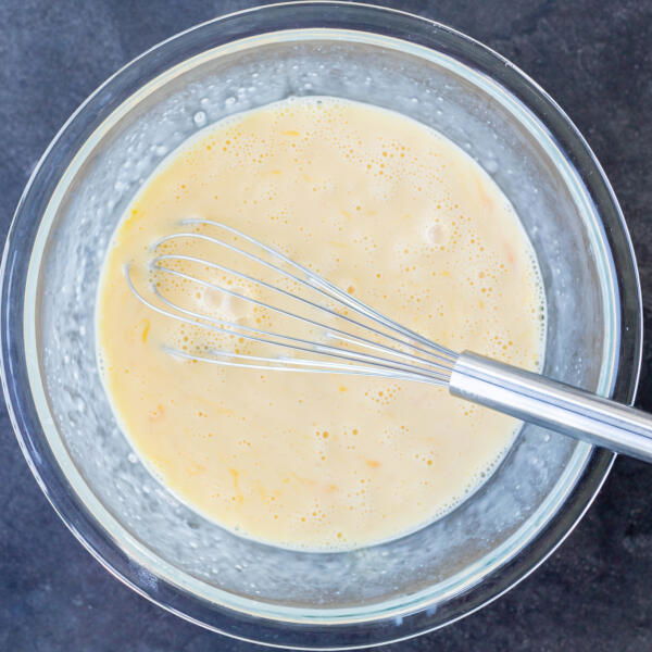 Eggs, milk and half and half in a bowl.