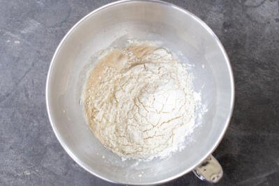 Flour added in a mixing bowl with liquids.