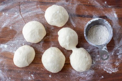 Dough balls shaped on a floured surface.