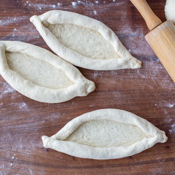 Shaped Khachapuri on a cutting board.