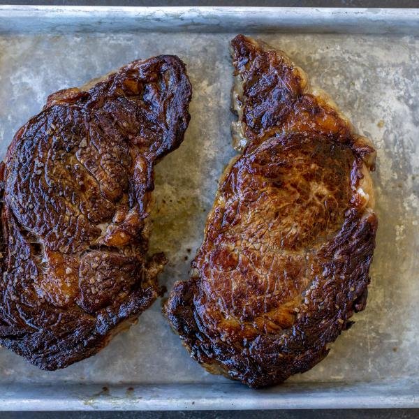 Resting ribeye on a baking sheet.