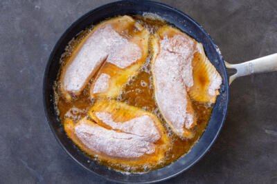Tilapia frying in a pan.
