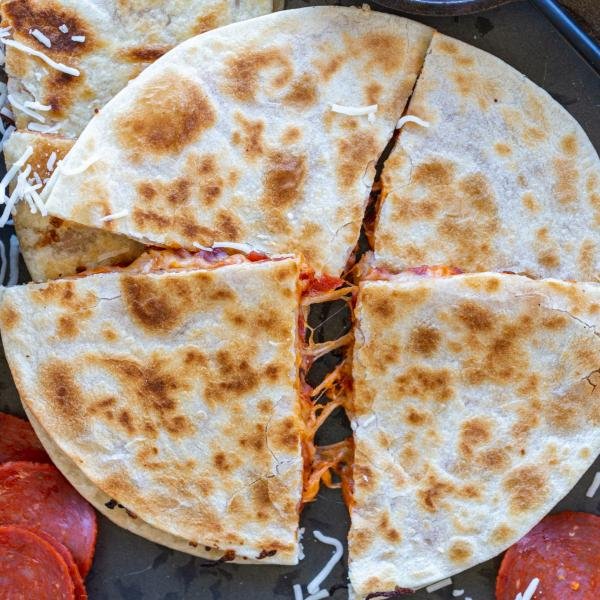 Pizza Quesadilla on a pan with pepperoni and cheese.