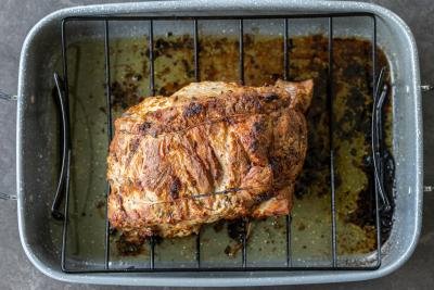 Roasted pork shoulder roast on a baking pan.
