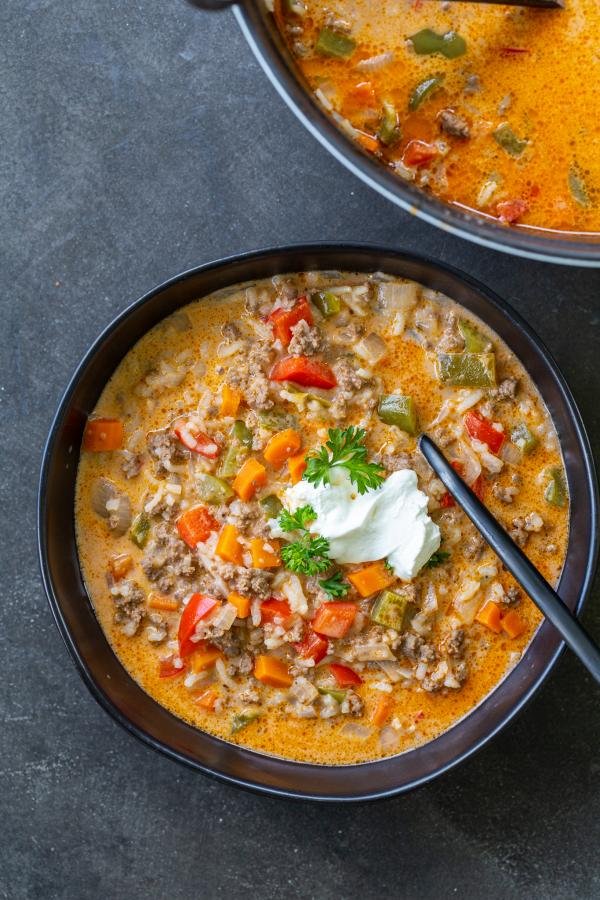 Stuffed Peppers Soup in a bowl with a spoon and topped with sour cream. 