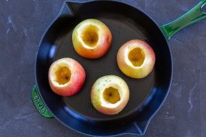 Apples scooped out on a baking pan.