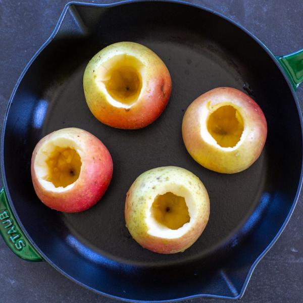 Apples scooped out on a baking pan.