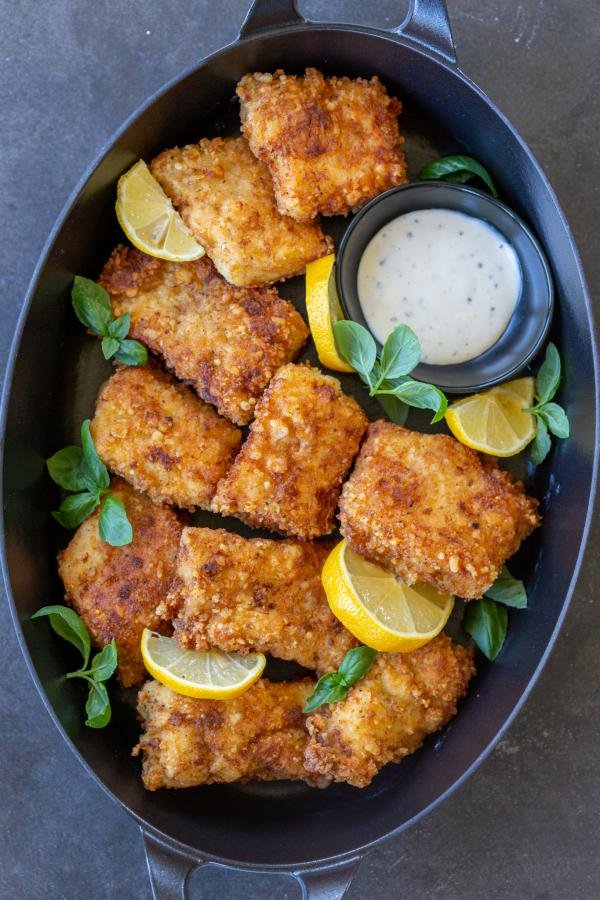 Crispy Panko Fish on a serving tray with lemon wedges. 