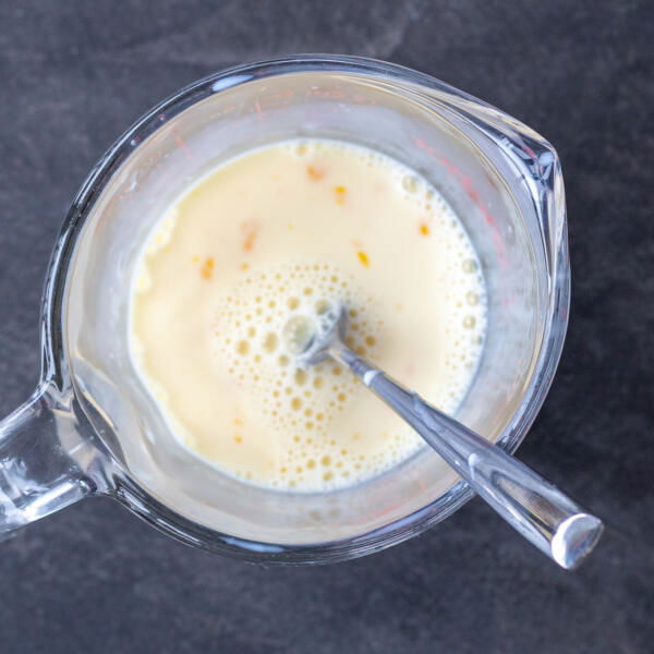 Milk with egg in a measuring cup.
