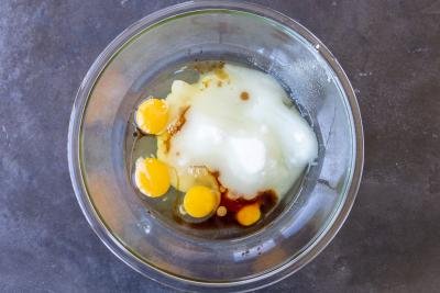 Sugar, eggs and vanilla extract in a bowl.