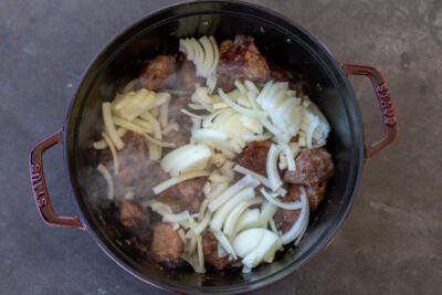 Browned lamb in a pot with onion.