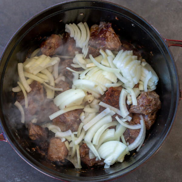 Browned lamb in a pot with onion.
