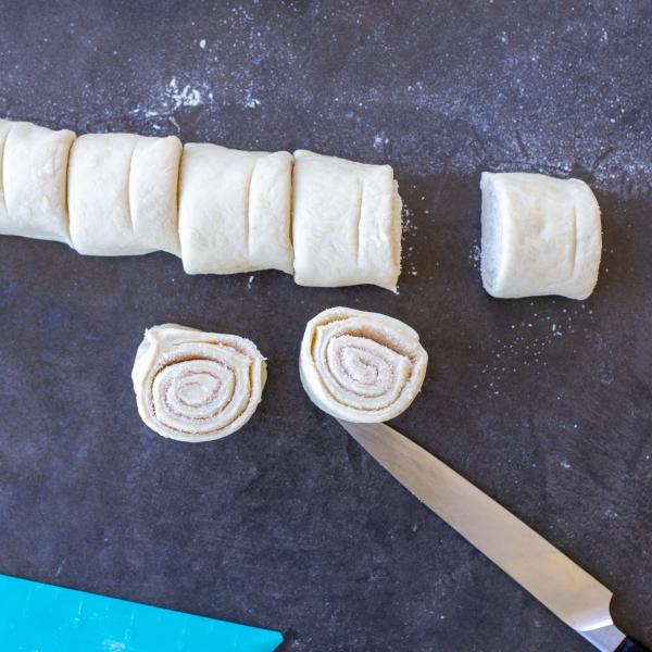 Rolled up cinnamon rolls dough cut into pieces.