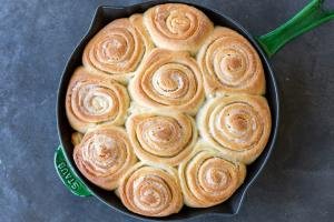 Baked cinnamon rolls on a baking pan.