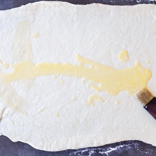 Butter applied to rolled out cinnamon rolls dough.