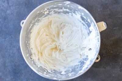 Whisked cream cheese frosting in a mixing bowl.