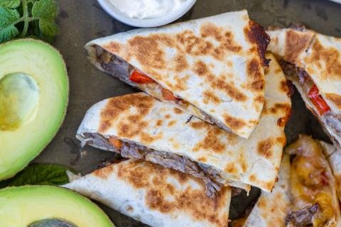 Steak Quesadilla with avocado and dippings.