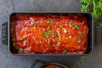 Turkey meatloaf in a baking pan with herbs.