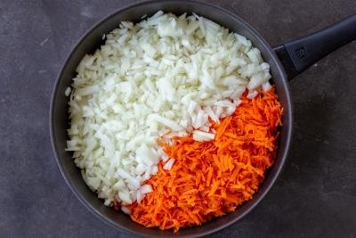 Carrots and onions in a frying pan.