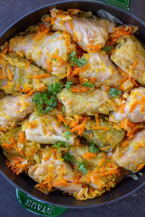 Vegetarian cabbage rolls in a pan with veggies. 