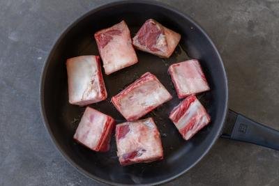 Short ribs in a pan cooking.