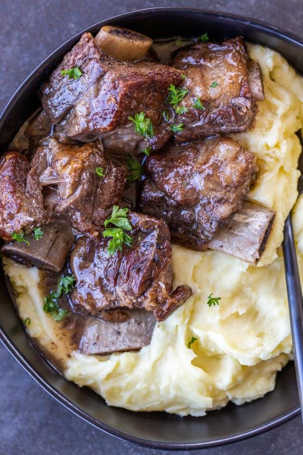 Short ribs with mashed potatoes in a bowl.