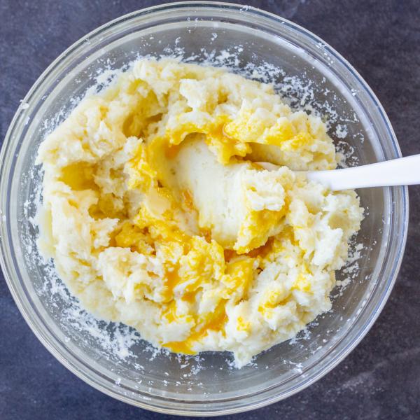 Mushed potatoes with cream, butter and eggs in a bowl.