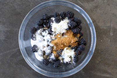 Blackberry, sugar, brown sugar and starch in a bowl.