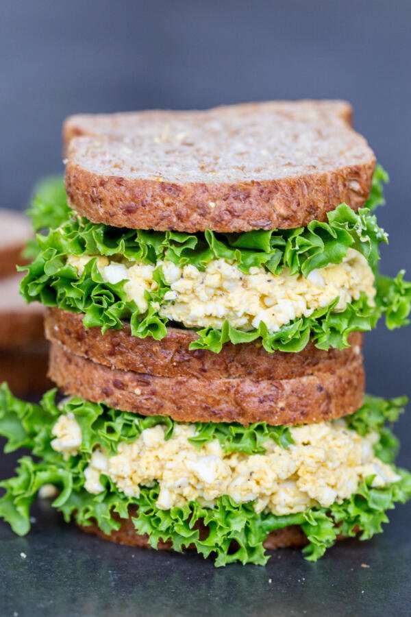 Egg salad sandwiches on top of each other.   