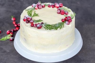 White chocolate cranberry cake on a stand.