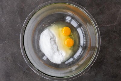 Eggs with sugar in a mixing bowl.