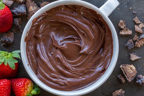 Chocolate Ganache in a bowl with berries and chocolate.