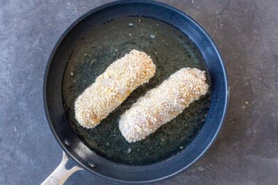 Chicken Kiev in a frying pan with oil.