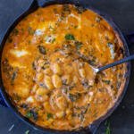 Creamy Cheesy Baked Gnocchi in a pan with a spoon.