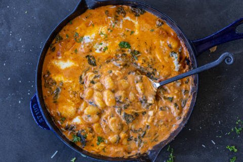 Creamy Cheesy Baked Gnocchi in a pan with a spoon.