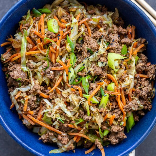 Egg roll in a bowl with green onions.