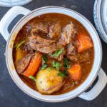 Lamb stew in a pot with herbs.