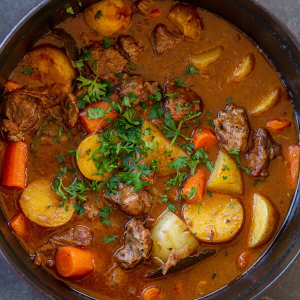 One-Pot Lamb Stew in a pot with herbs.