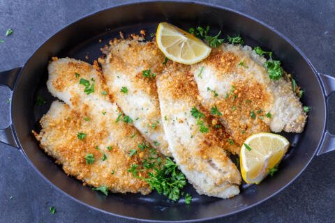 Parmesan Crusted Tilapia on a tray with lemon.