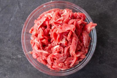 Beef sliced into pieces in a bowl.