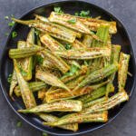 Roasted okra on a plate with herbs.