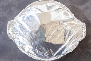 Wrapped with foil in a pan.