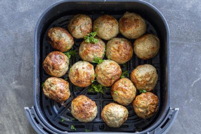 Turkey meatballs in an air fryer basket.